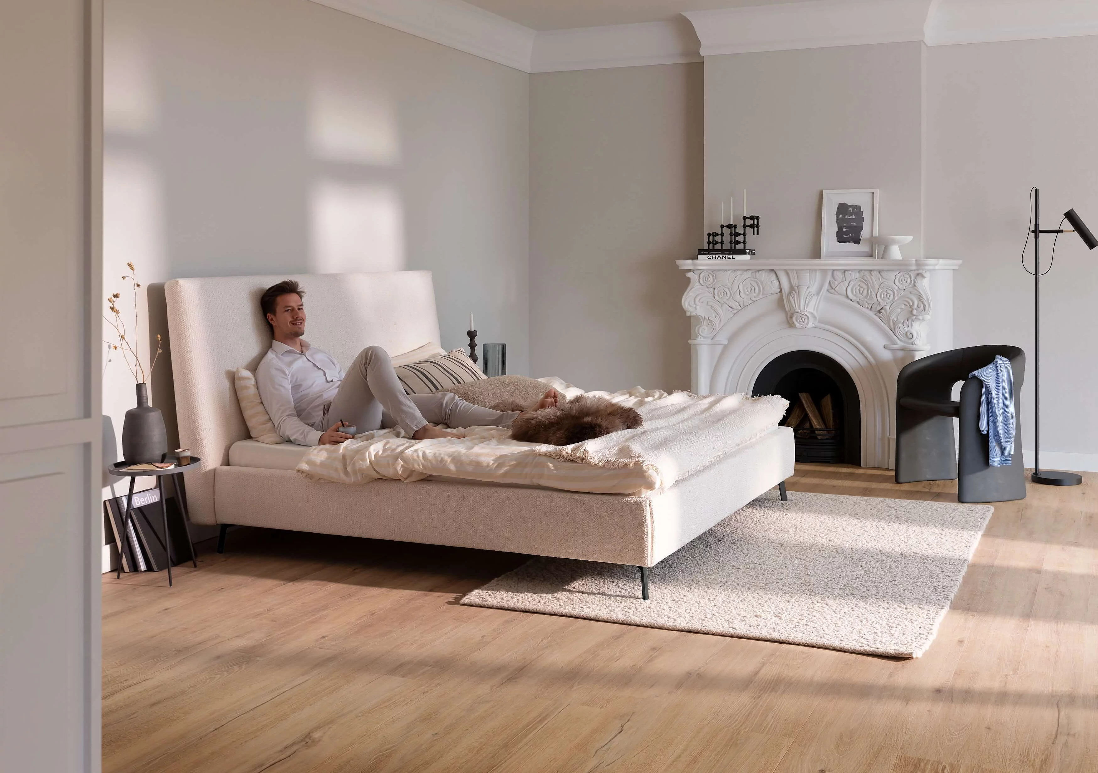 Doppelbett mit weißem Bezug, hohem Kopfteil und schlanken schwarzen Metallfüßen in einem wohnlichen Ambiente