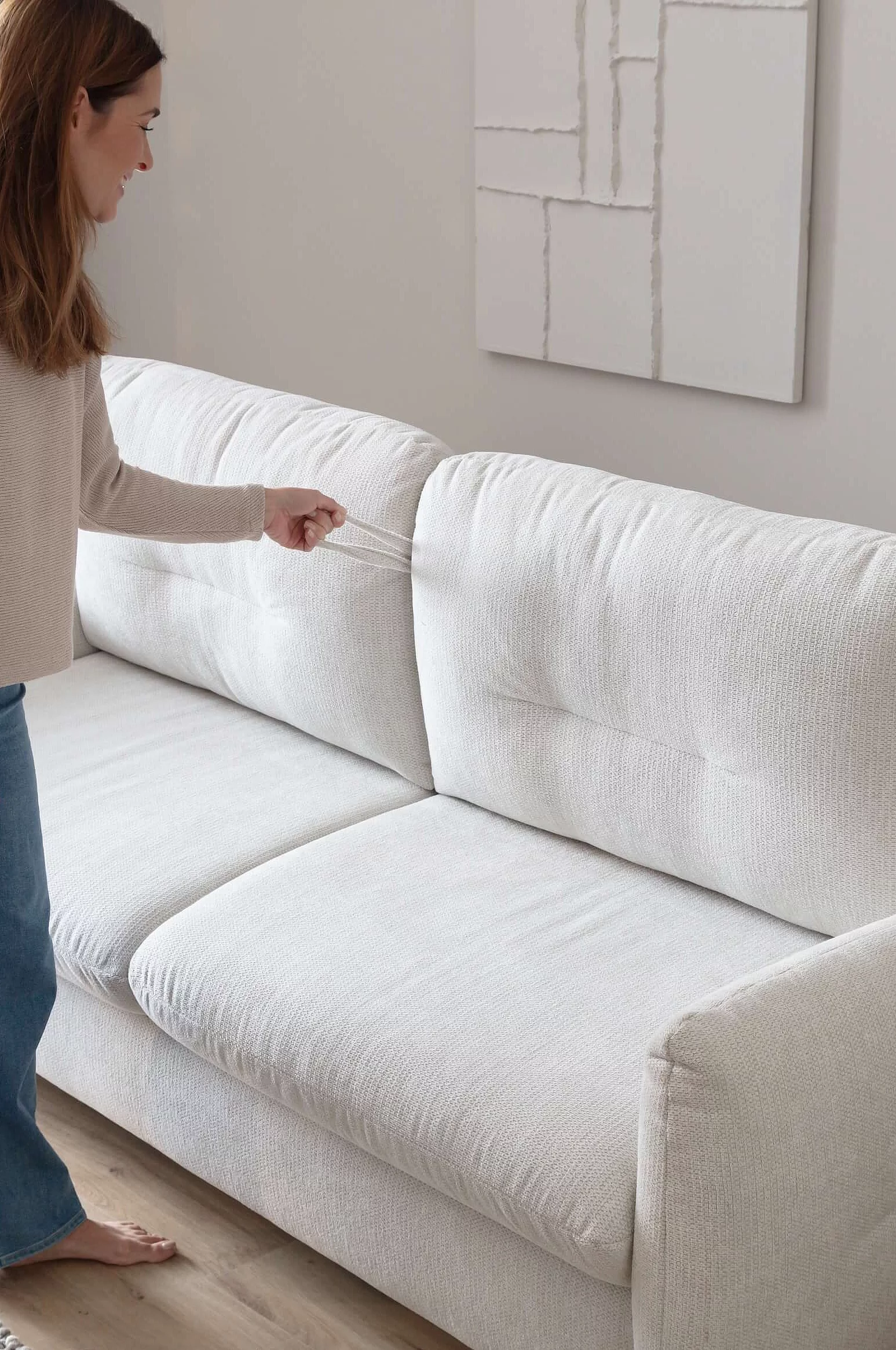 Schlafsofa Cassie in Bezug Famous in der Farbe Snow beim Aufziehen der Schlaffunktion in Wohnambiente