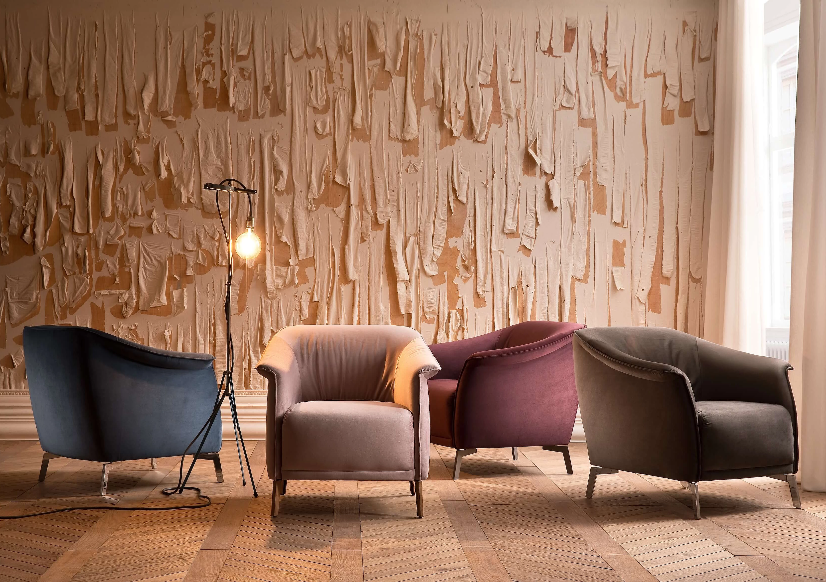 Lou armchair upholstered in velvet in the colours bluegrey, rosewood, purple and stone in a cosy atmosphere