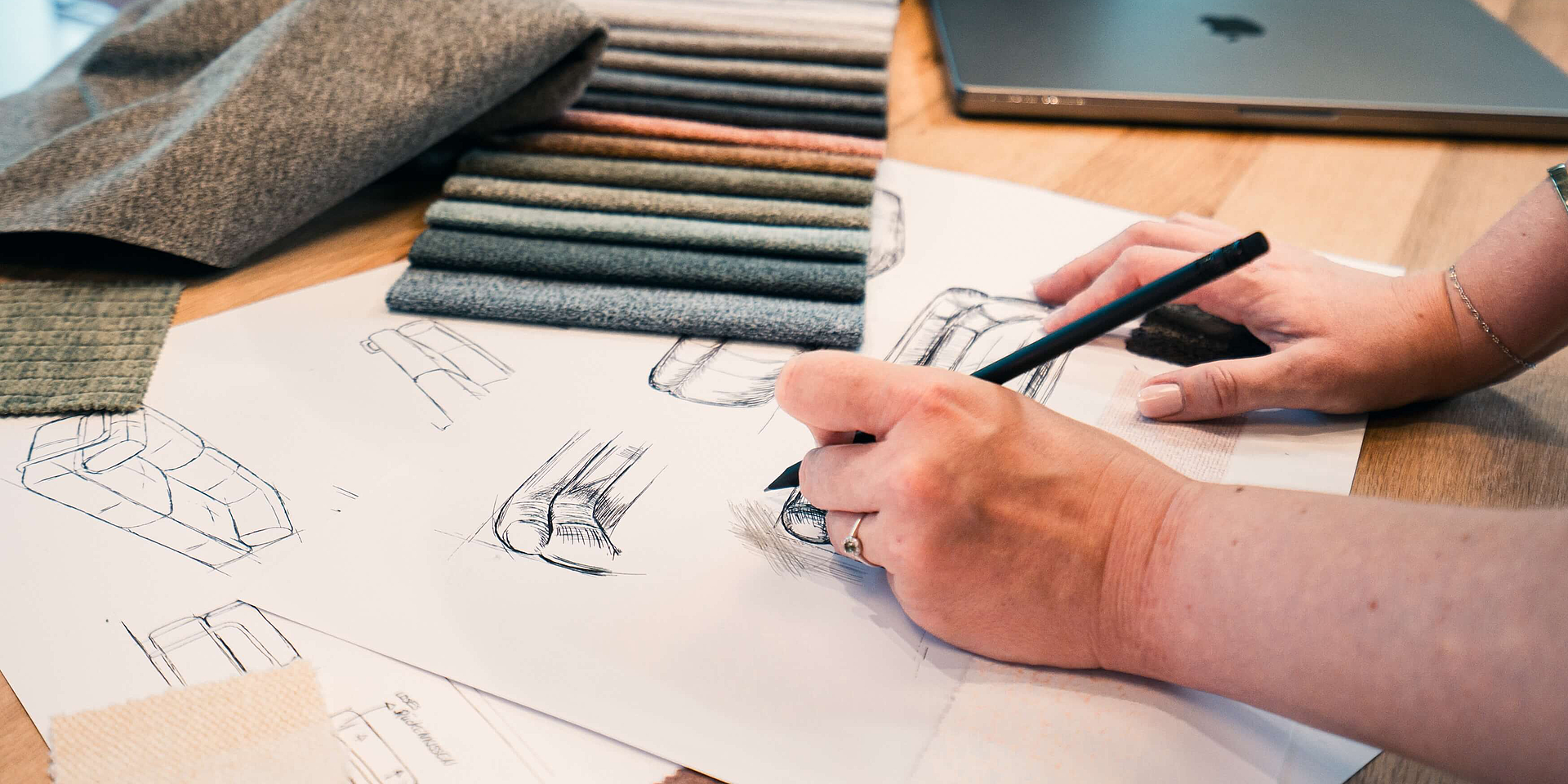 Detailansicht eines Tischs mit Skizzen und Stoffmustern in der Kreation