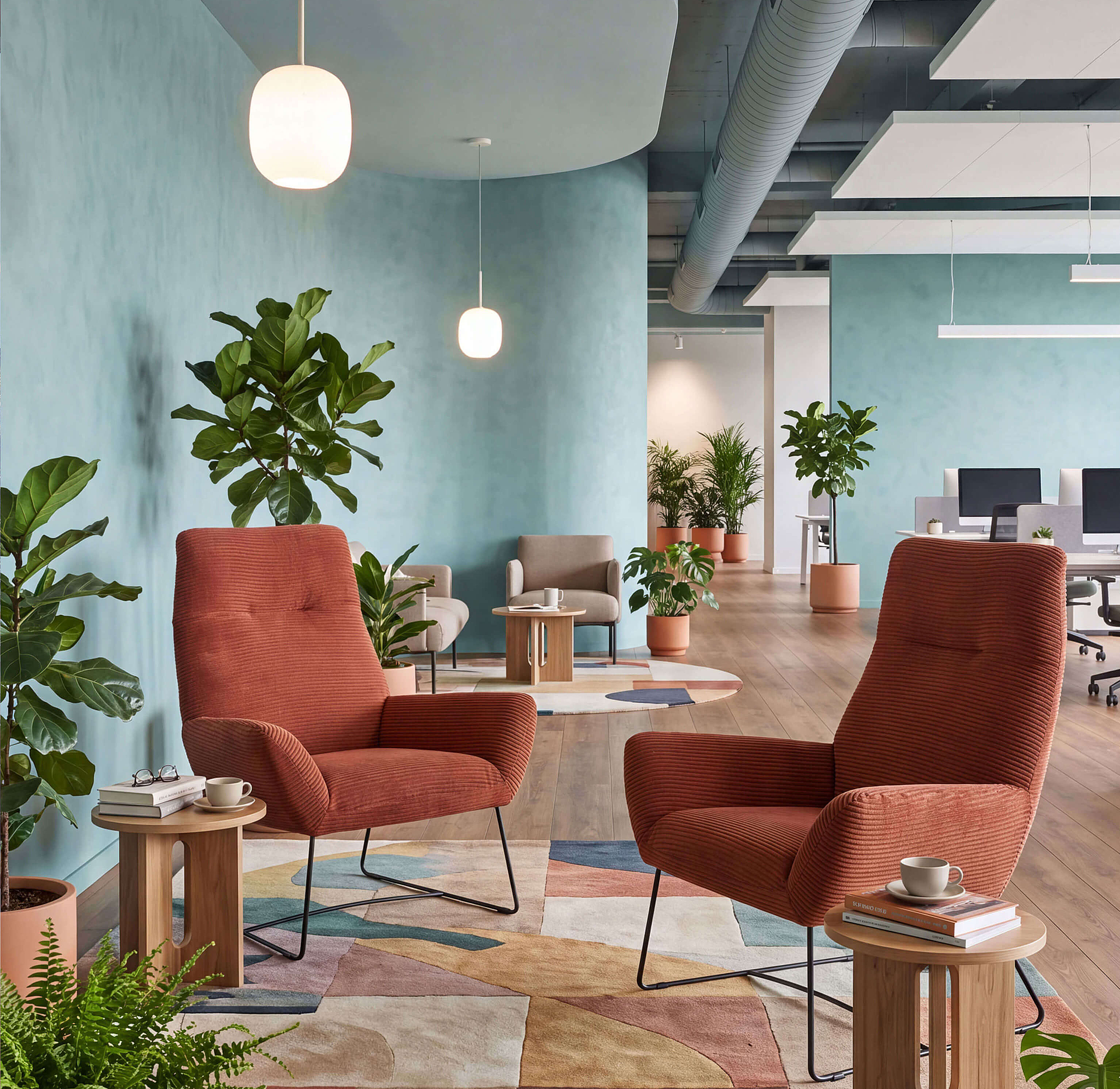 Basic armchair with corduroy upholstery in an office area with warm lighting and workstations in the background